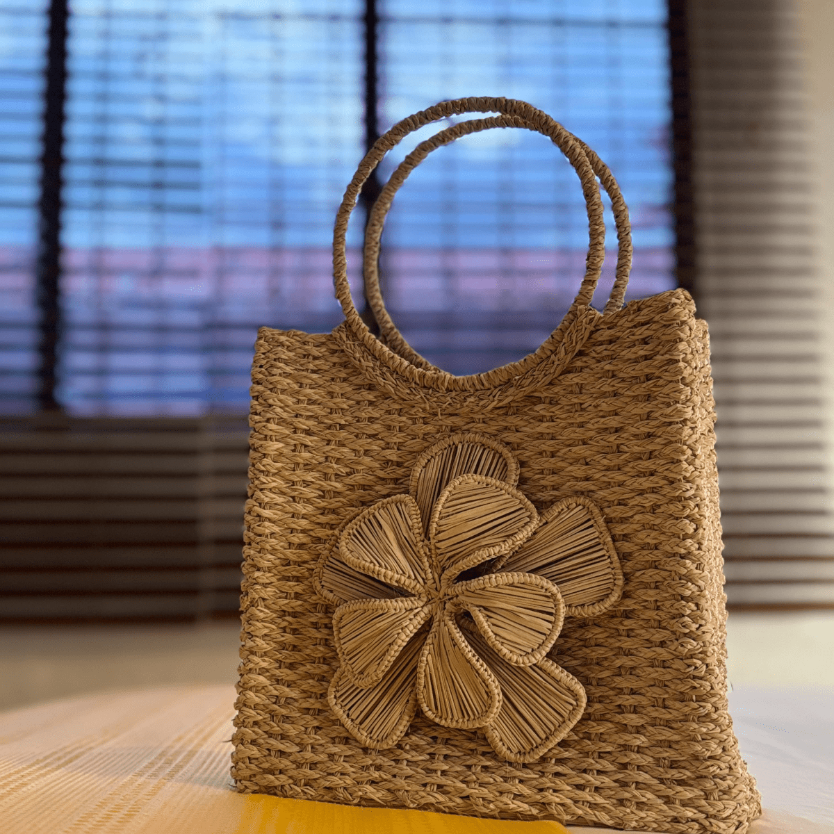 Canasto elaborado en palma de iraca con una flor central color beige