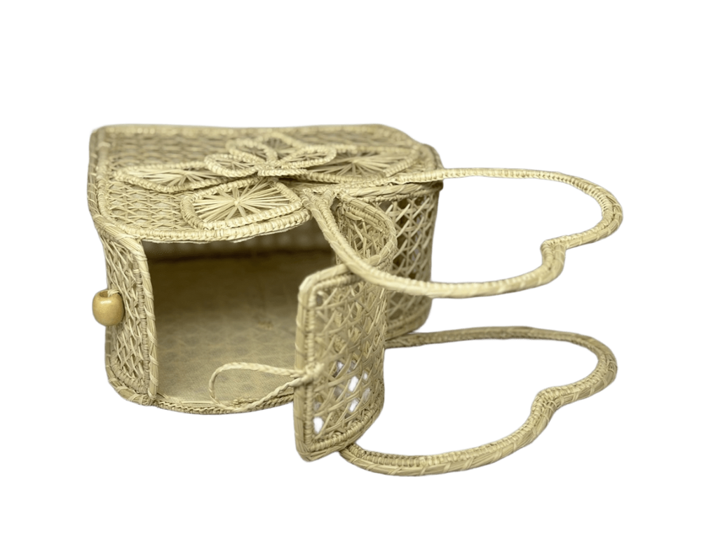 Bolso acostado elaborado en palma de iraca tipo corazón con una flor central color beige y aza beige