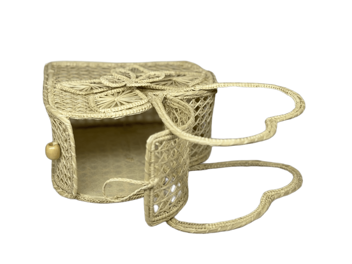 Bolso acostado elaborado en palma de iraca tipo corazón con una flor central color beige y aza beige