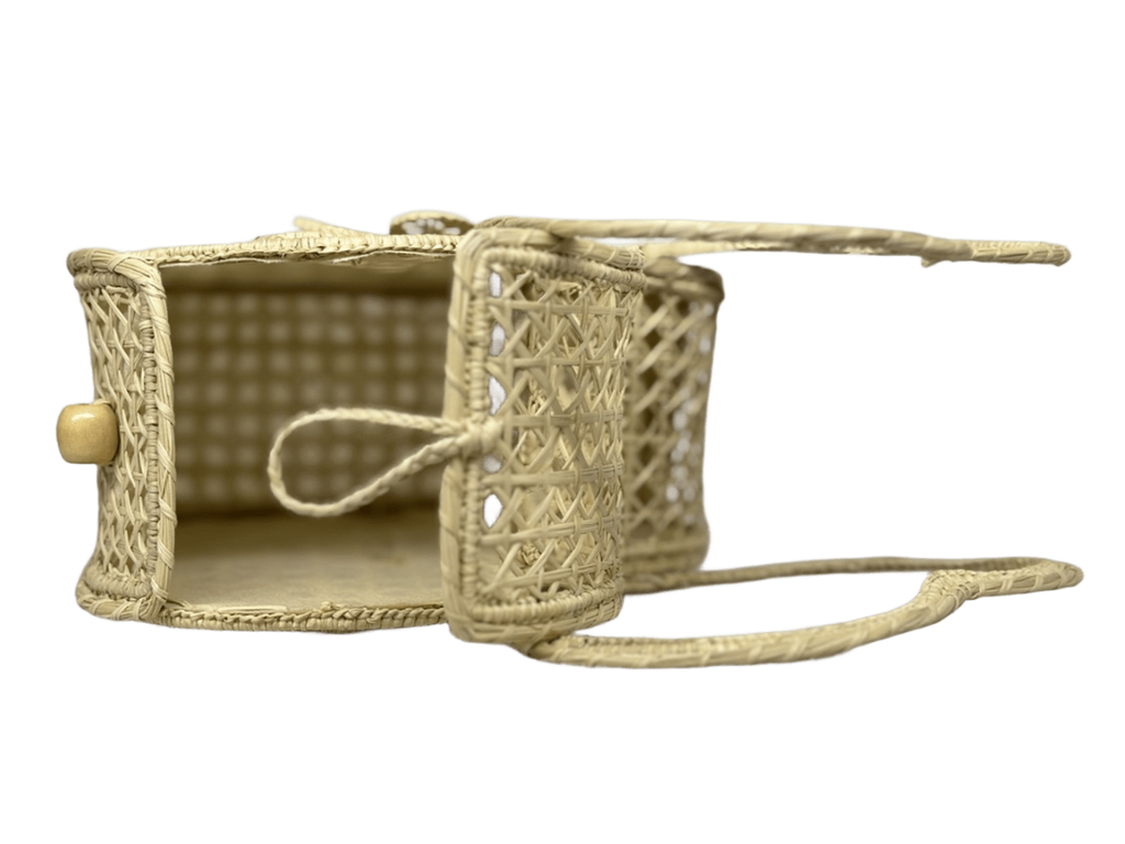 Bolso acostado elaborado en palma de iraca tipo corazón con una flor central color beige y aza beige