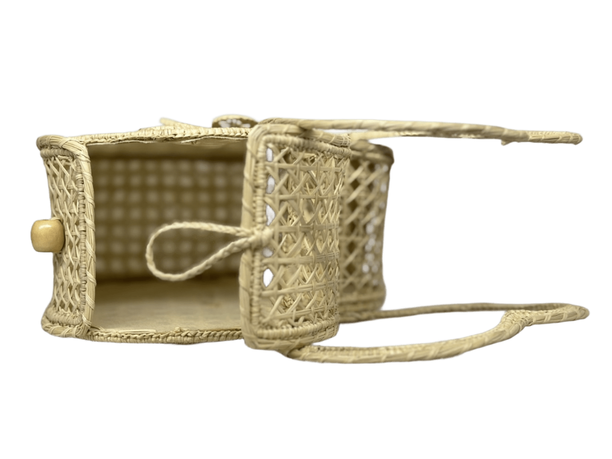 Bolso acostado elaborado en palma de iraca tipo corazón con una flor central color beige y aza beige