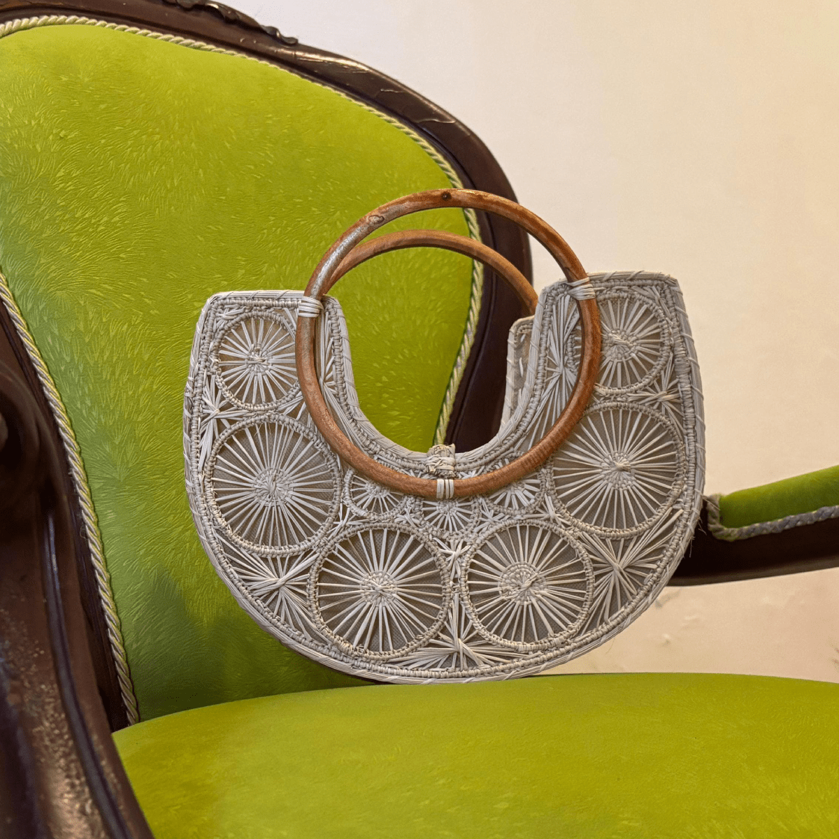 Bolso elaborado en palma de iraca en forma de media luna con aza de madera