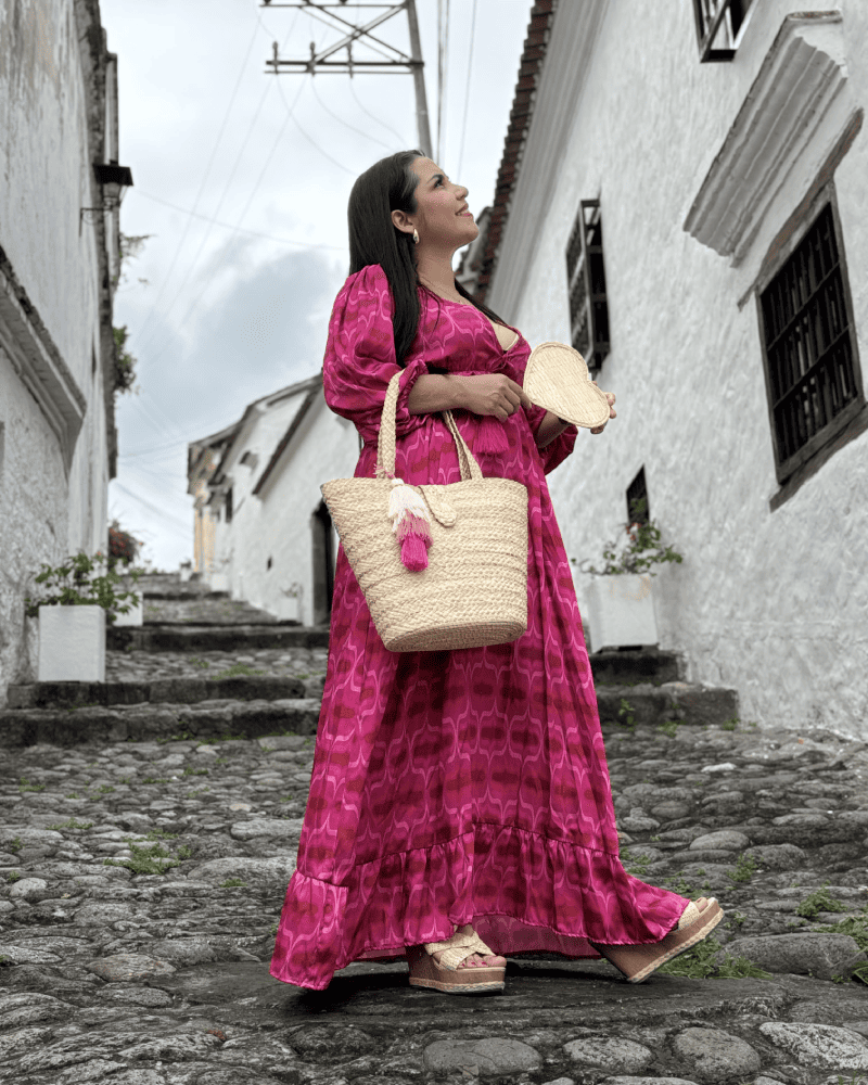 Mujer de perfil con abanico y canasto elaborado en palma de iraca