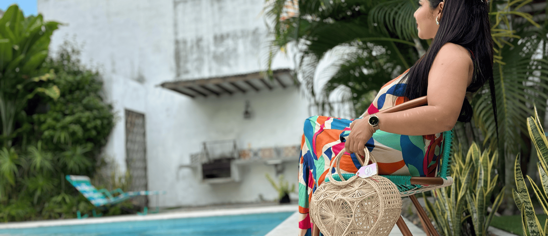 Mujer de perfil sosteniendo un cofre tipo corazón frente a una piscina