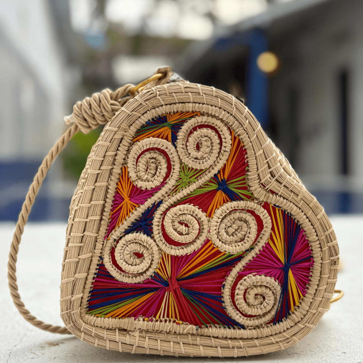 Bolso yoyo elaborado en palma de iraca en forma de corazón colorido con lazo beige